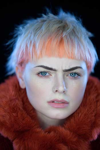model headshot photograph with straw pink hair and faux fur neck wrap